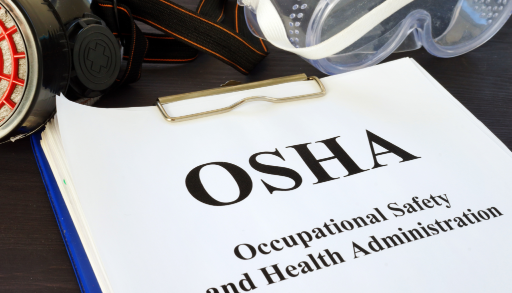 A clipboard with a paper on which OSHA is written, and Occupational Safety and Health Administration written beneath.